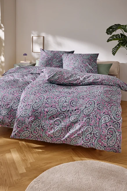 Bliska perspektywa łóżka z różową pościelą w paisley.