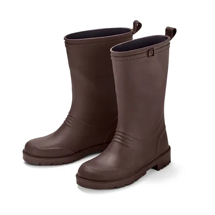 Zwei braune, recycelbare Gummistiefel stehen nebeneinander auf einem weißen Hintergrund.