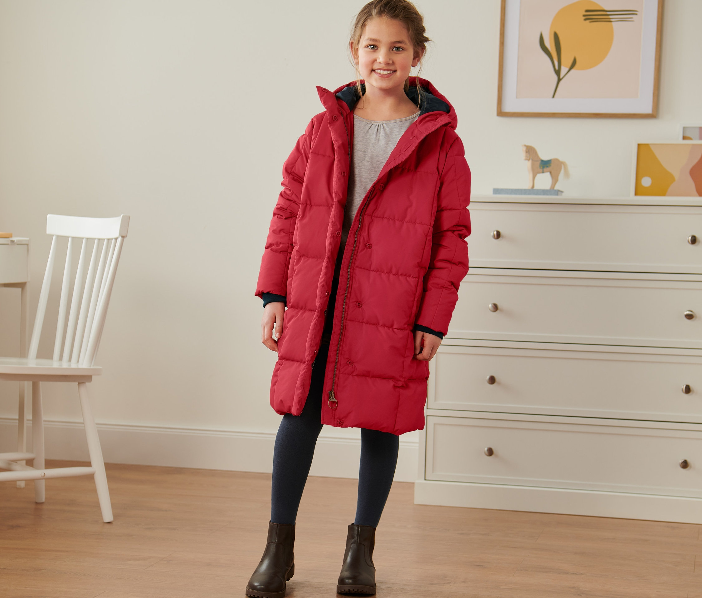 Dziewczyna stoi w czerwonym ocieplanym płaszczu.