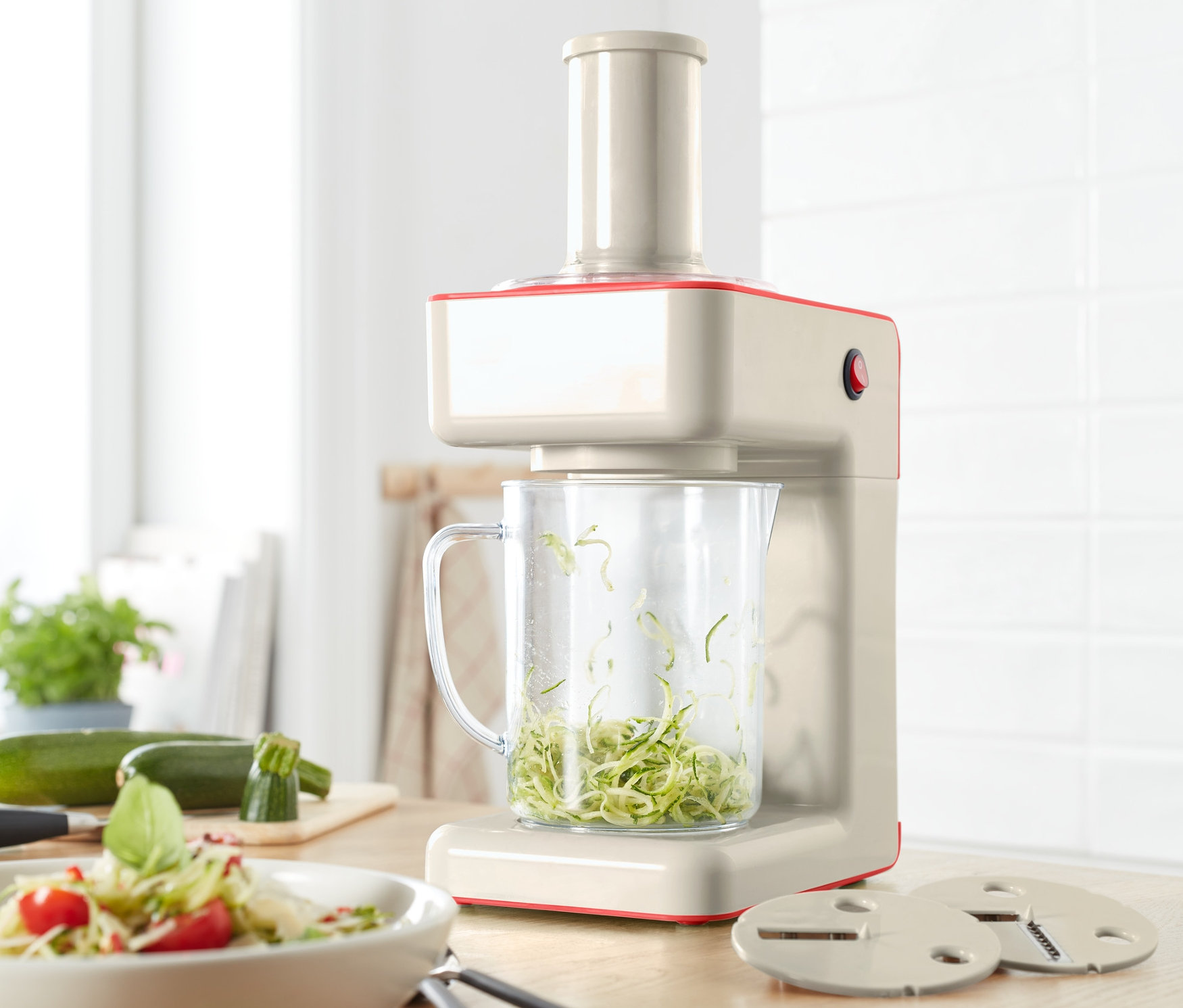 Elektryczna krajalnica spiralna z pokrojoną cukinią w pojemniku.