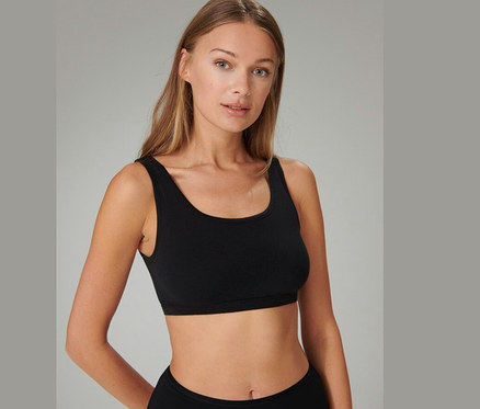 Kobieta ma na sobie czarną braletkę z bawełny ekologicznej SCHIESSER.