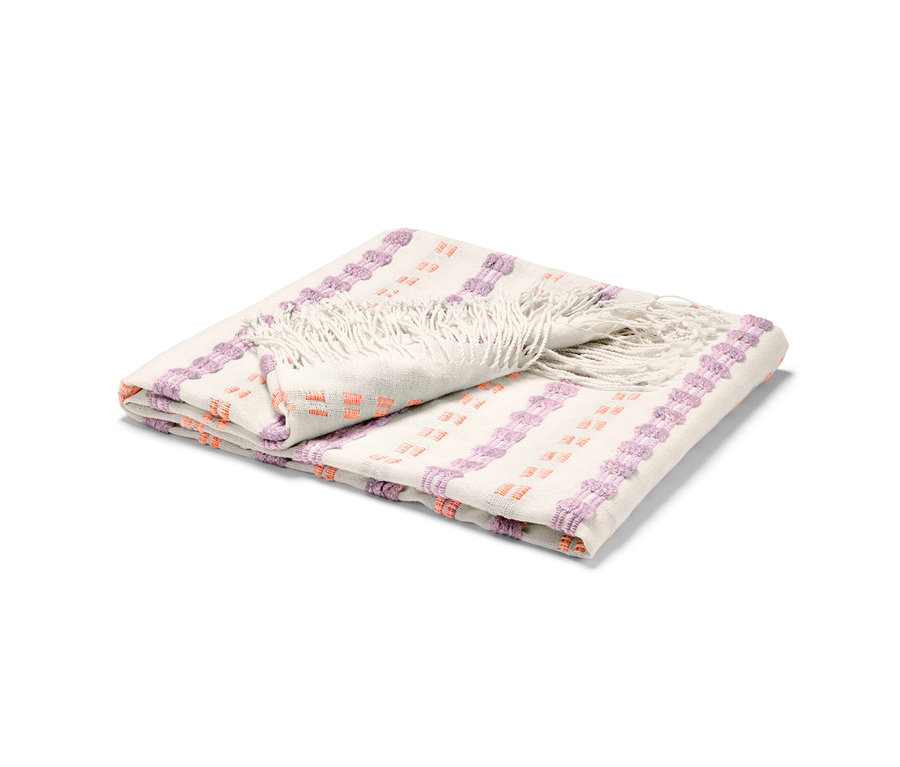 Złożona narzuta z frędzlami oraz fioletowo-pomarańczowymi wzorami.