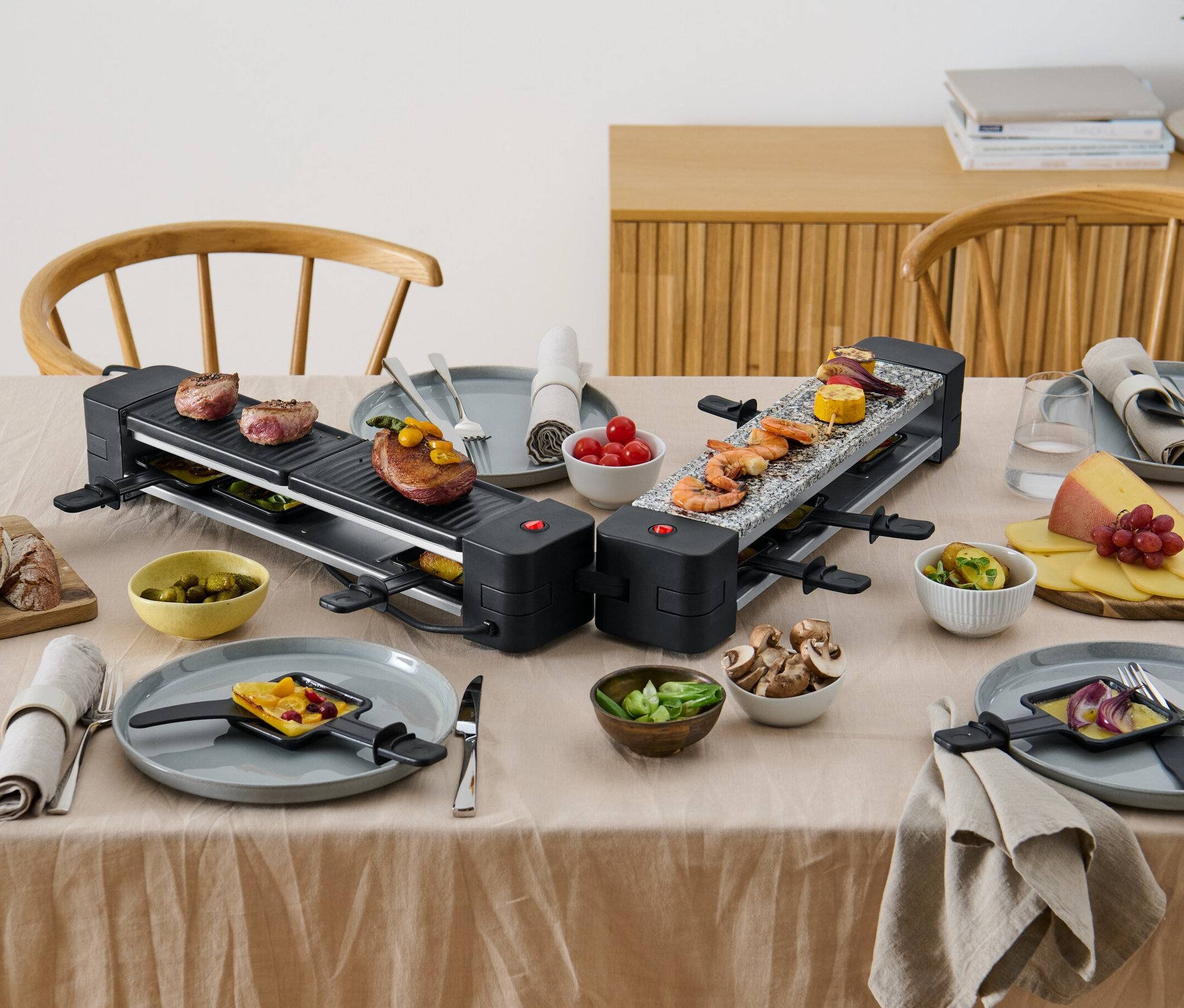 Dwa składane grille do raclette z jedzeniem na stole.
