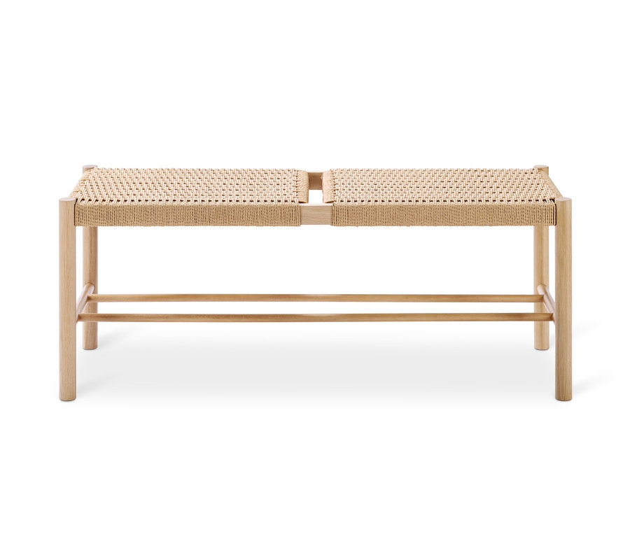 Drewniana ławka z plecionym siedziskiem.