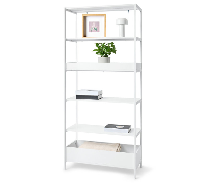 Biały regał z pięcioma półkami z rośliną, ramką na zdjęcia, lampą, dwoma pudełkami i kocem.