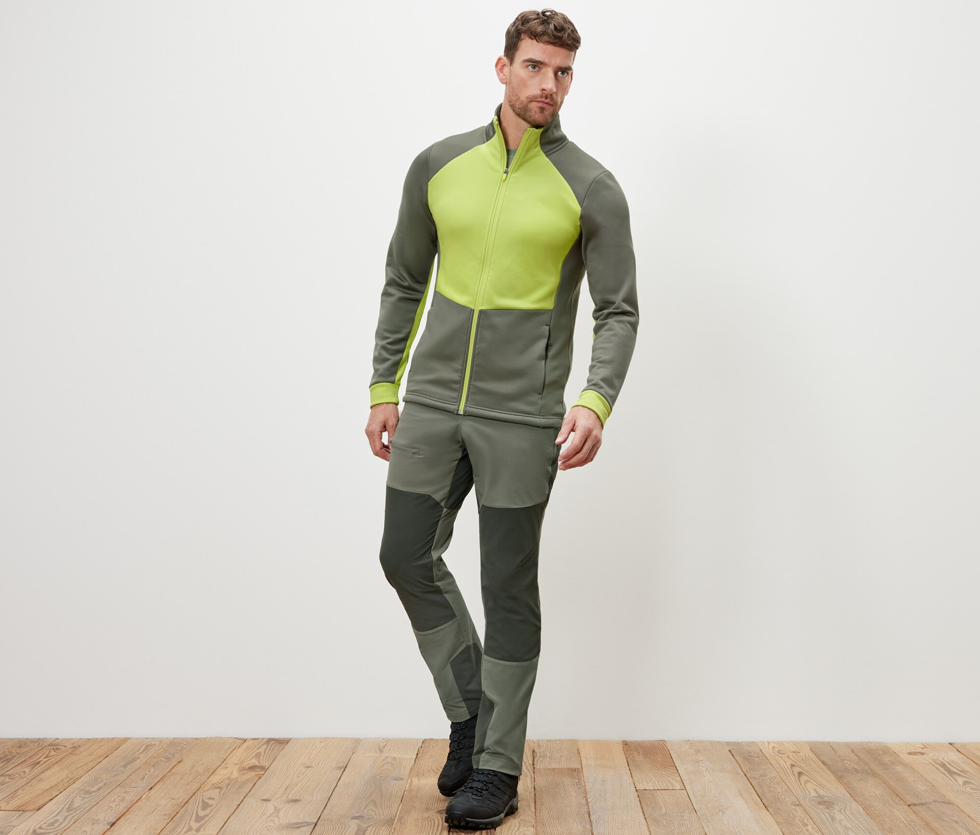 Mężczyzna pozuje w kurtce termoaktywnej i spodniach.