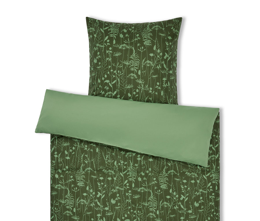 Zielona pościel we wzory roślinne i jasnozielona poduszka.