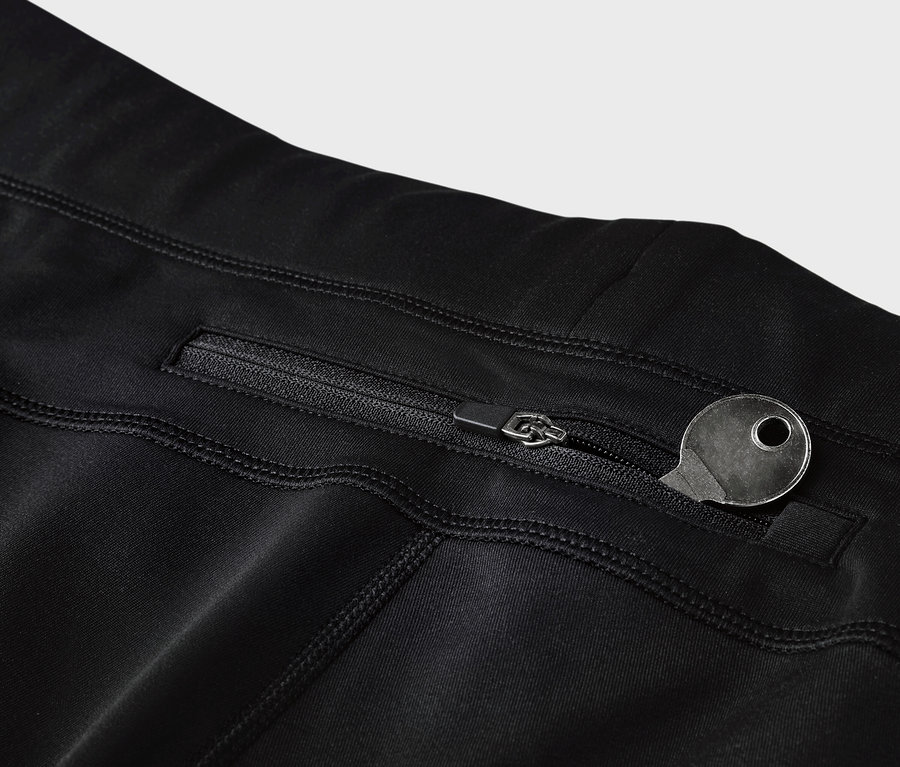 Szczegół czarnych legginsów z kieszenią na zamek i kluczem.