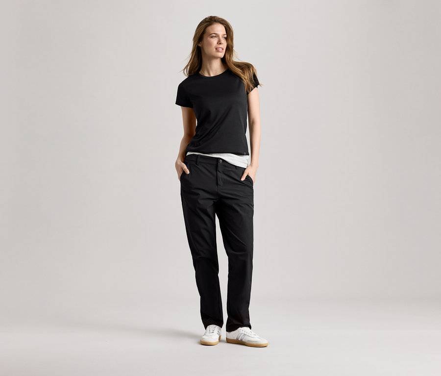 Kobieta w czarnej koszulce sportowej i spodniach. Koszulka sportowa jest czarna.