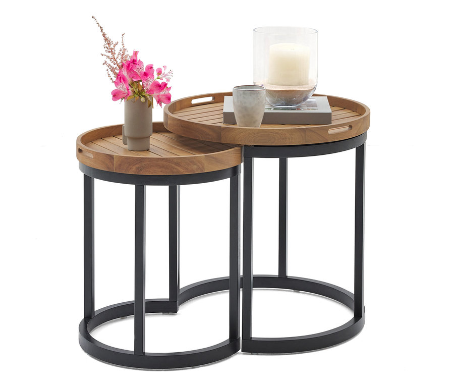 Dwa okrągłe stoliki boczne z drewna i metalu, jeden z wazonem z różowymi kwiatami, a drugi ze świecą w szklanym naczyniu i filiżanką.