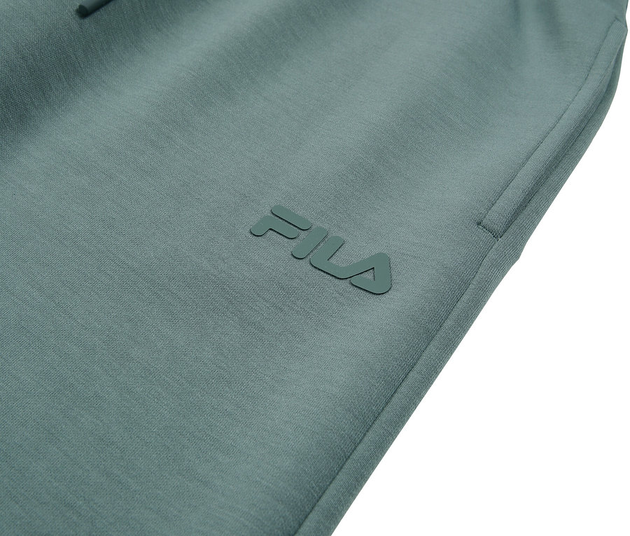 Zbliżenie turkusowych spodni dresowych Fila ze sznurkiem.