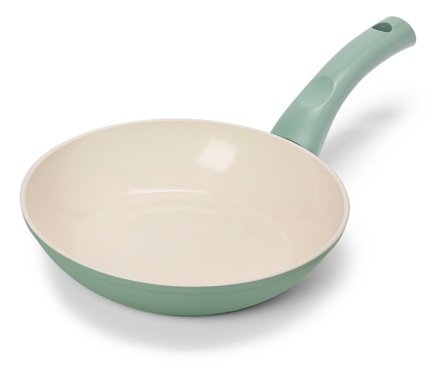 Jasnozielona patelnia z kremowym wnętrzem leży na białym tle.