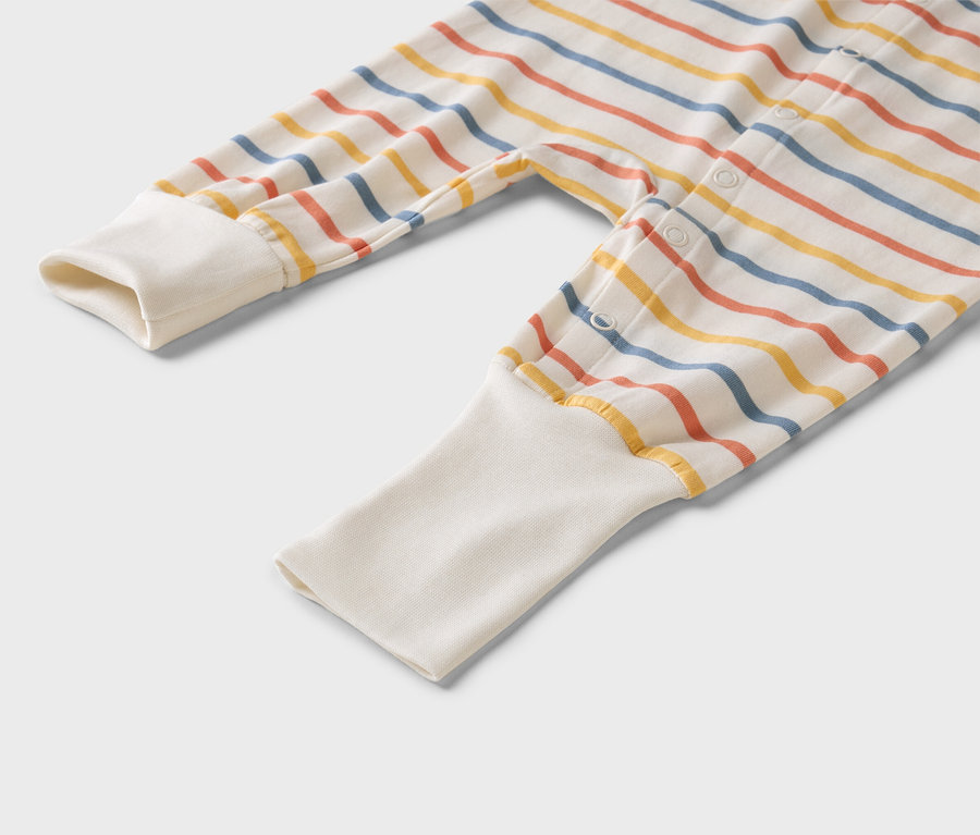 Zbliżenie na pasiasty pajacyk niemowlęcy z białymi mankietami.