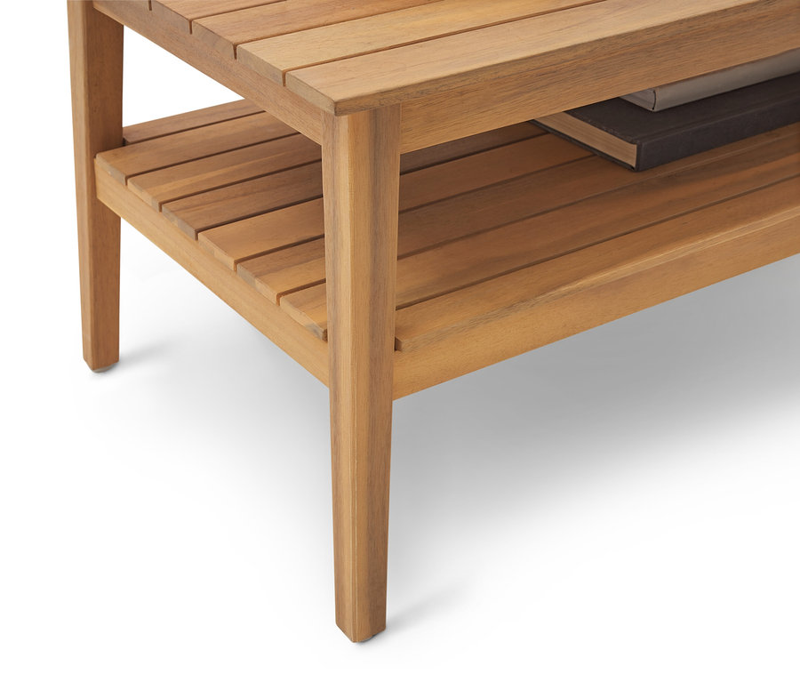 Zbliżenie na jasno brązowy drewniany stolik pomocniczy z półką i książką.