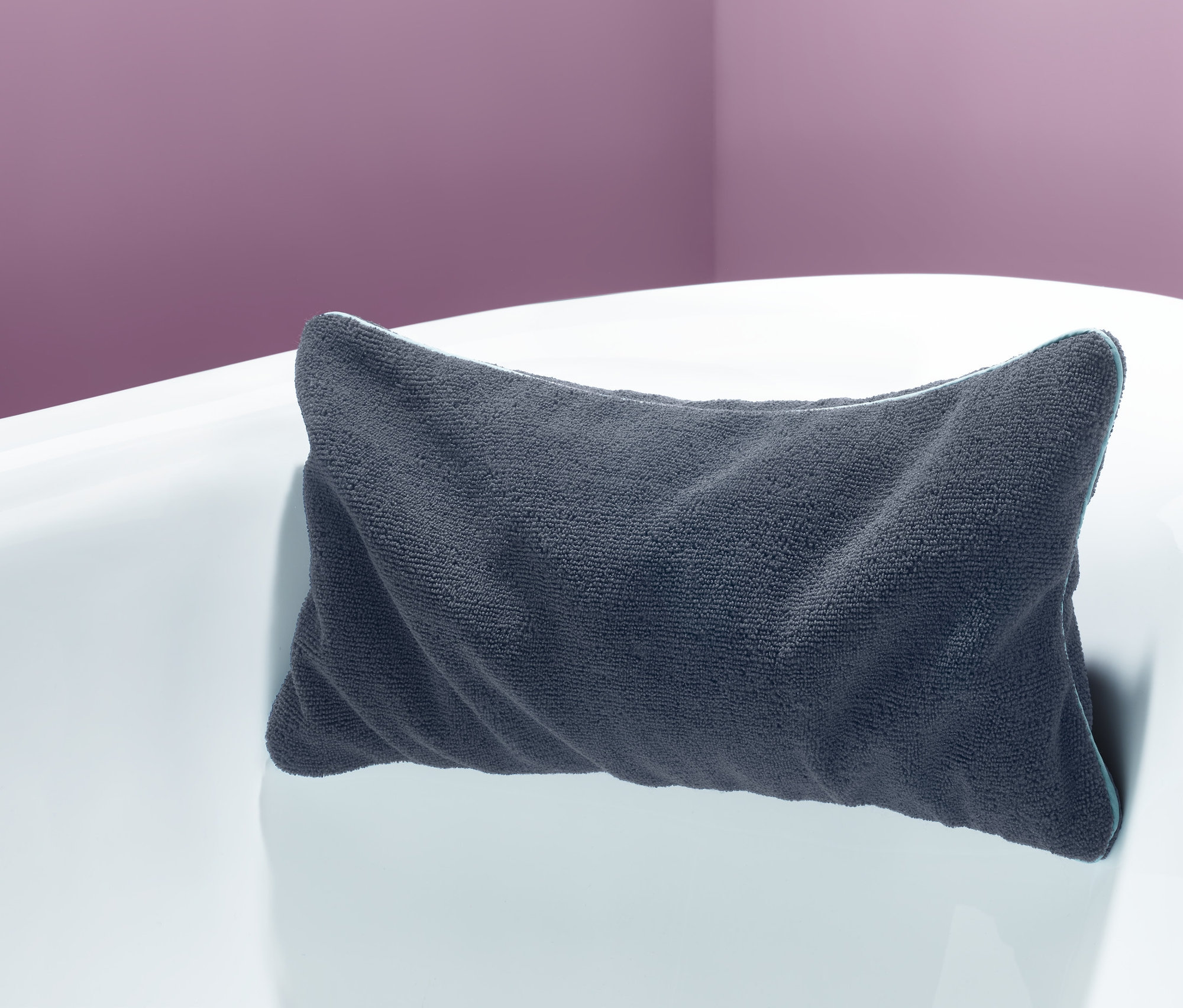 Szara poduszka do wanny na białej wannie.