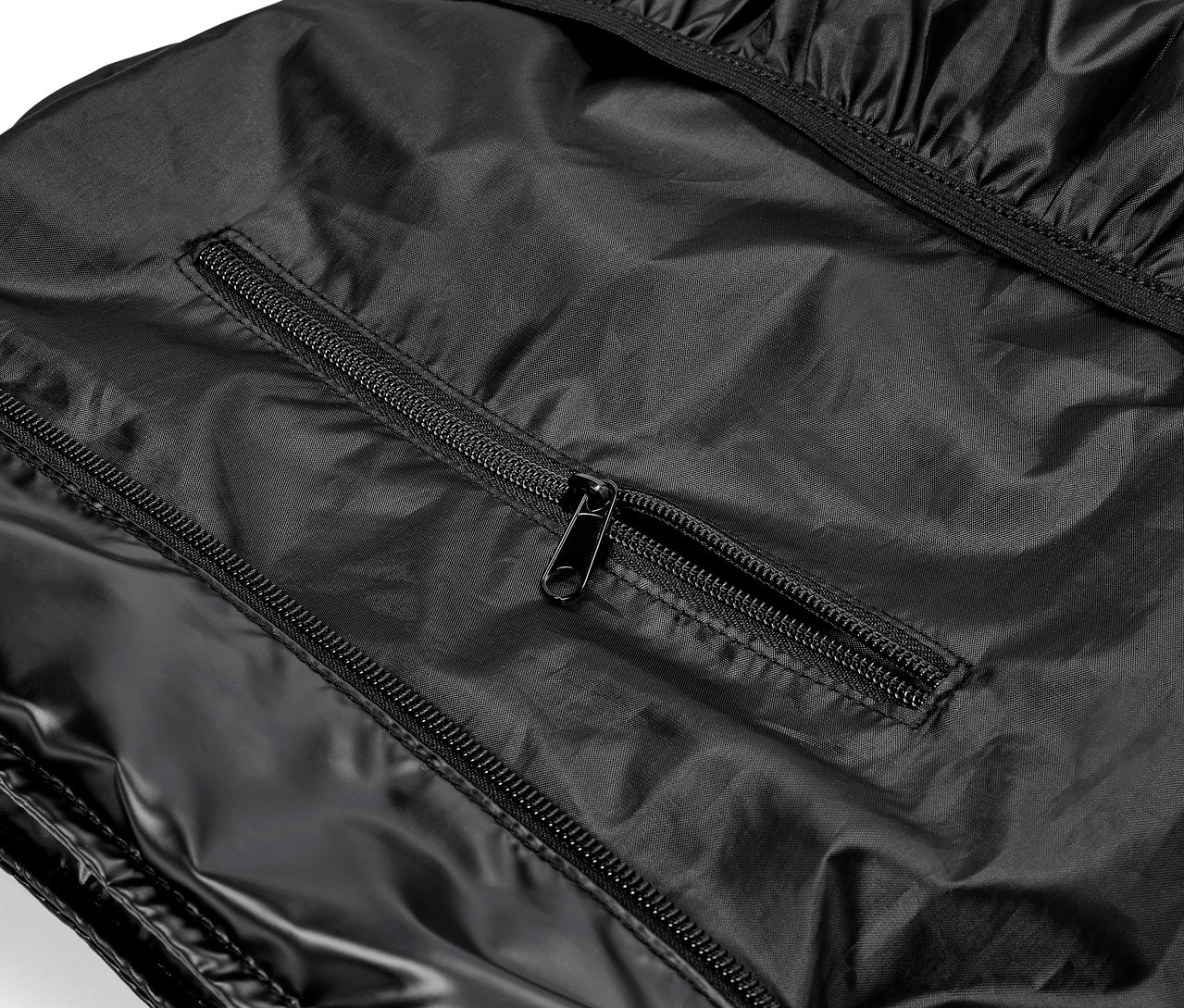 Szczegół błyszczącego, czarnego ubrania z zamkami błyskawicznymi.