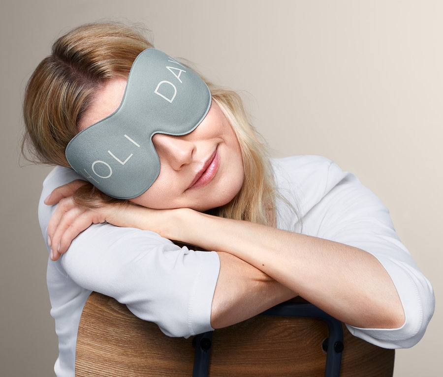 Blondwłosa kobieta odpoczywa w masce do spania 3D.