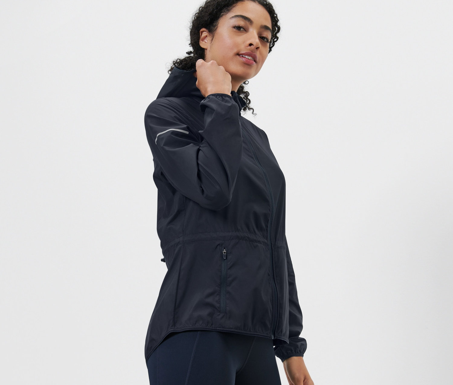 Kobieta pozuje w lekkiej kurtce do biegania.