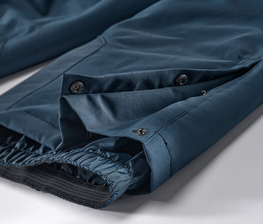 Szczegół granatowych spodni narciarskich z guzikami.