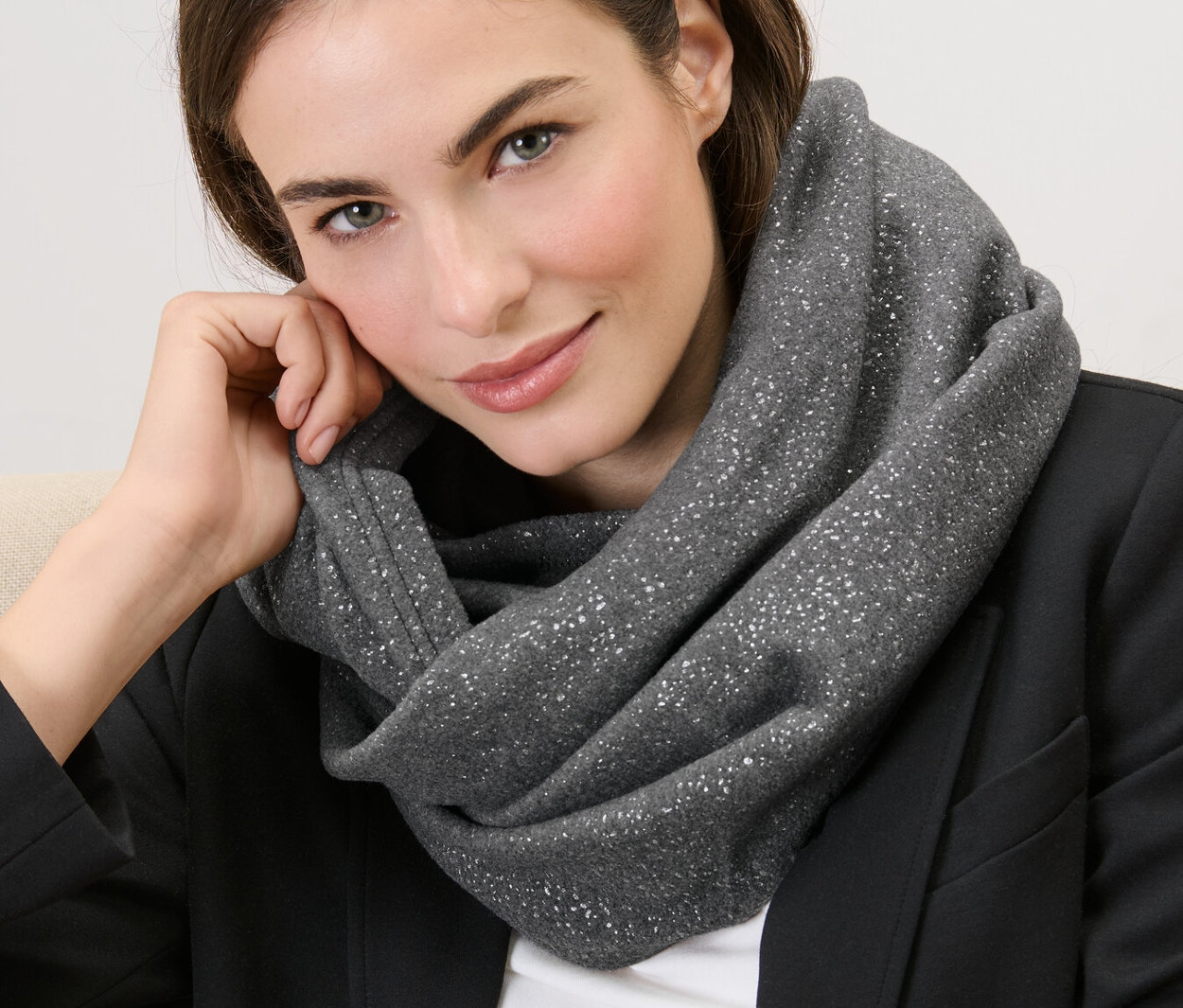 Kobieta siedzi w błyszczącym kominie z polaru.