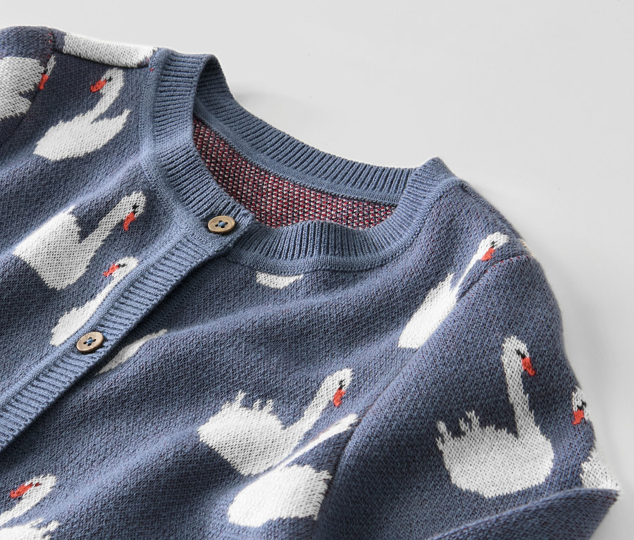 Zbliżenie na niebieski sweter rozpinany dla dzieci z łabędziami.