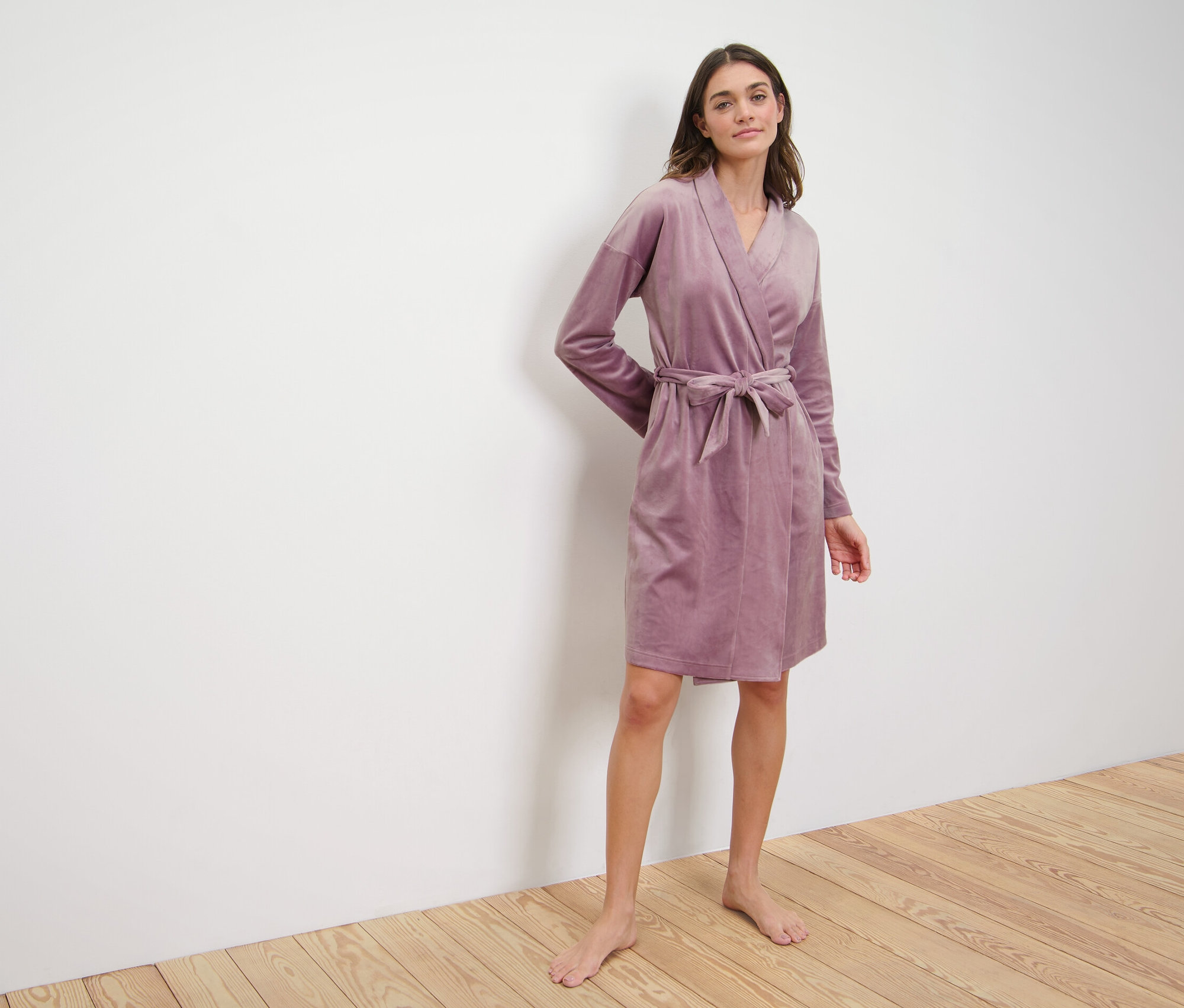 Kobieta ma na sobie welurowy szlafrok.