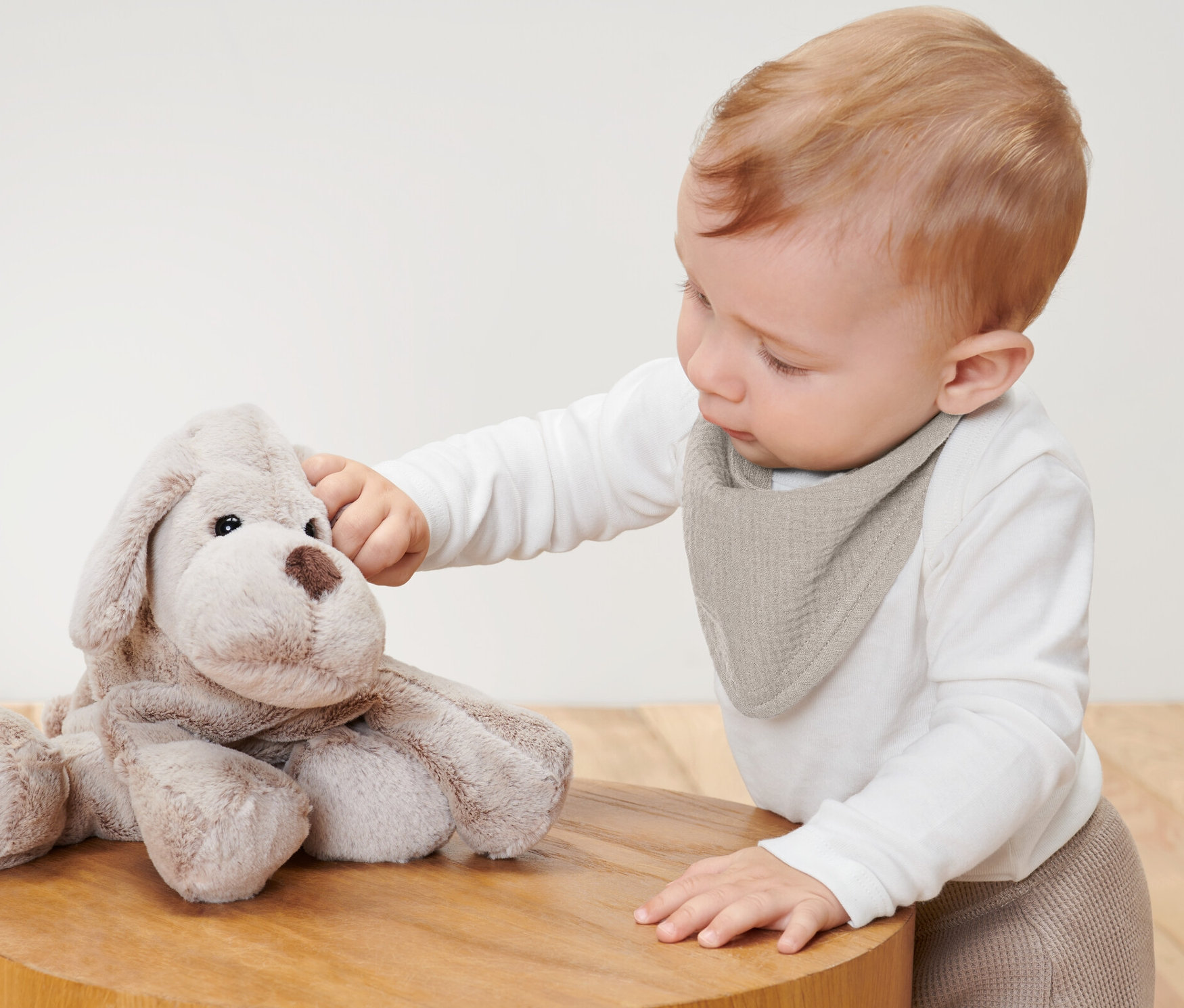 Dziecko dotyka pluszowego psa, ma na sobie muślinowe chustki na szyję, 2 sztuki.