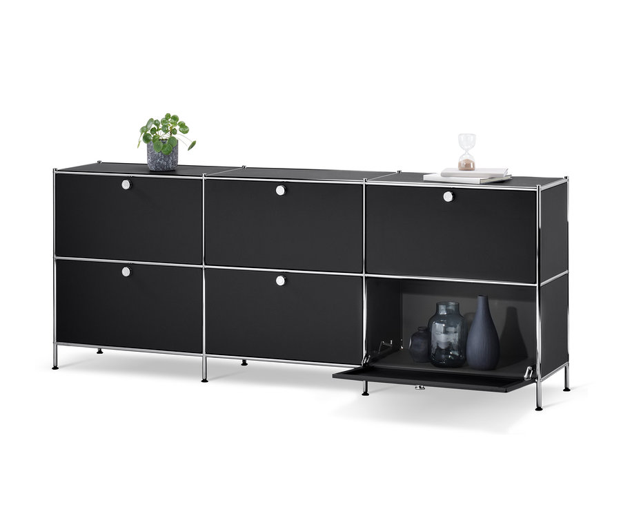 Czarna szafka typu sideboard »CN3« z 6 klapami, na której stoi wazon, książki i klepsydra.