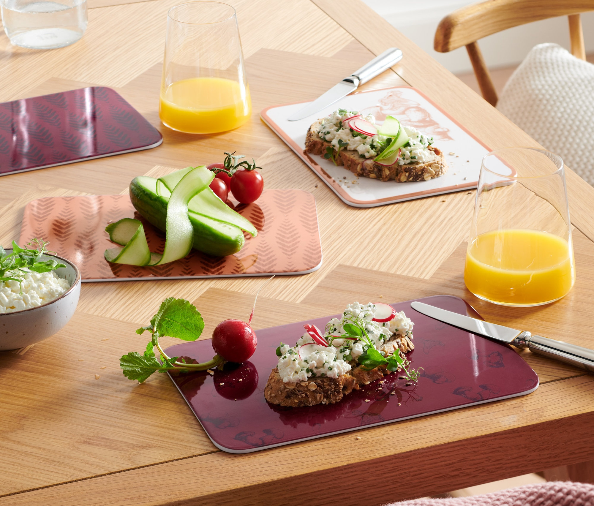 Cztery deski do krojenia z jedzeniem na drewnianym stole.