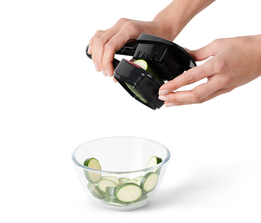 Ręce kroją warzywa krajalnicą Nicer Dicer Quick nad miską.