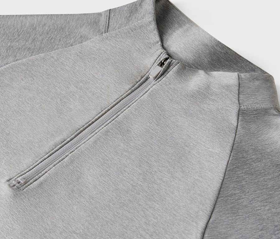 Szczegół jasnoszarej bluzy z zamkiem błyskawicznym.