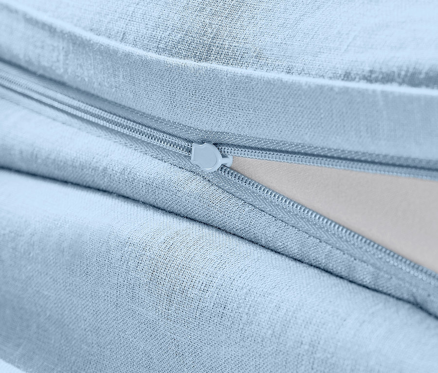 Zbliżenie na jasnoniebieską pościel lnianą w standardowym rozmiarze z zamkiem błyskawicznym.