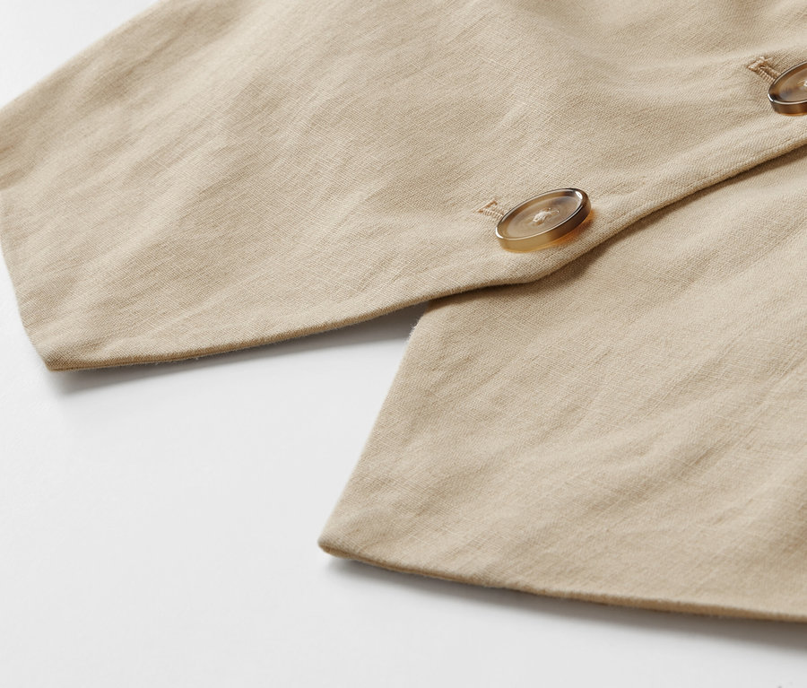Szczegół lnianej kamizelki z guzikami.