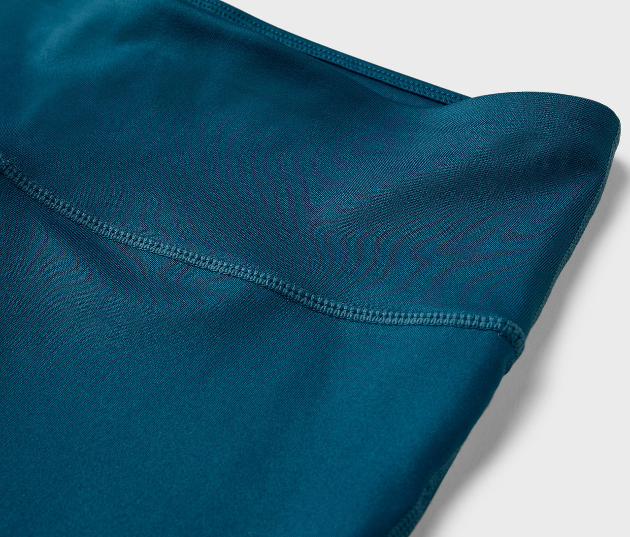 Szczegół legginsów sportowych o długości 3/4.