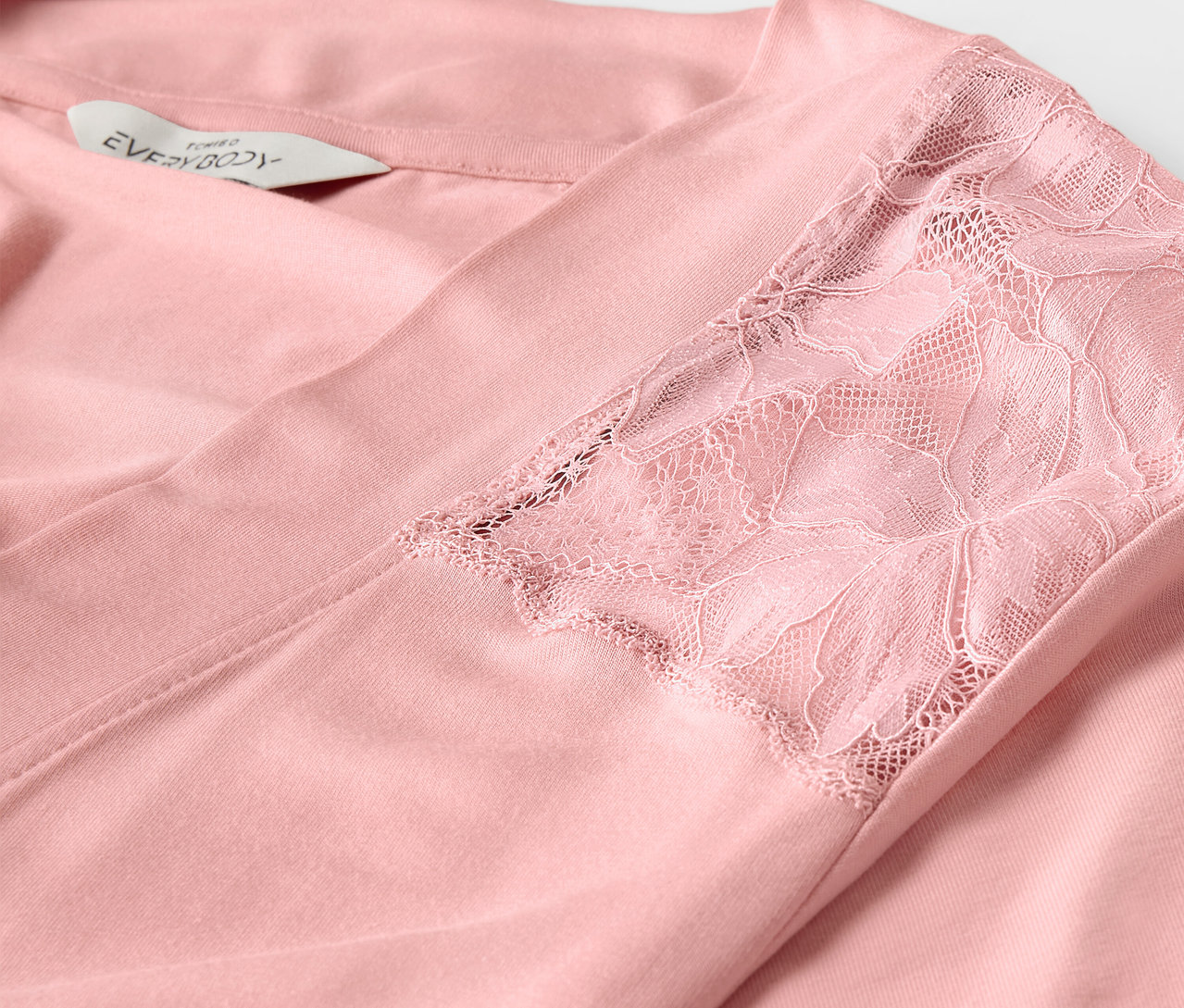 Szczegół różowego szlafroka z koronką na rękawie.