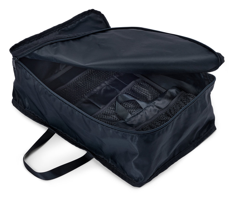 Otwarta, granatowa torba podróżna z zamkiem błyskawicznym i wieloma przegródkami, widok z góry.