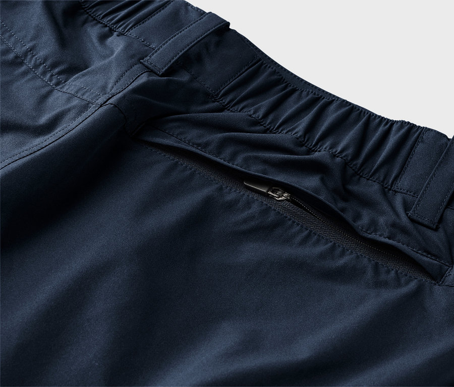 Zbliżenie granatowych spodni z elastycznym pasem i kieszenią na zamek.