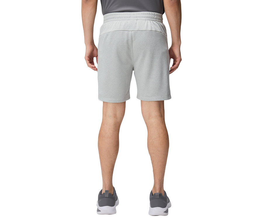 Widok z tyłu osoby ubranej w krótkie, jasnoszare spodenki i szare buty do biegania.