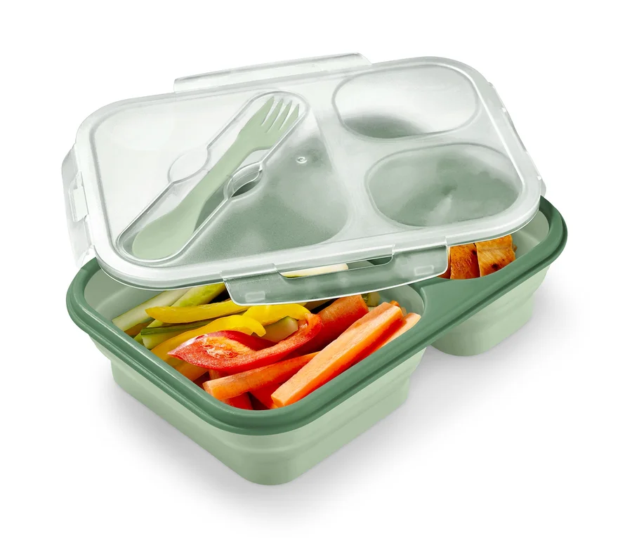 Zielony lunchbox składany z pokrojonymi warzywami i sztućcami.