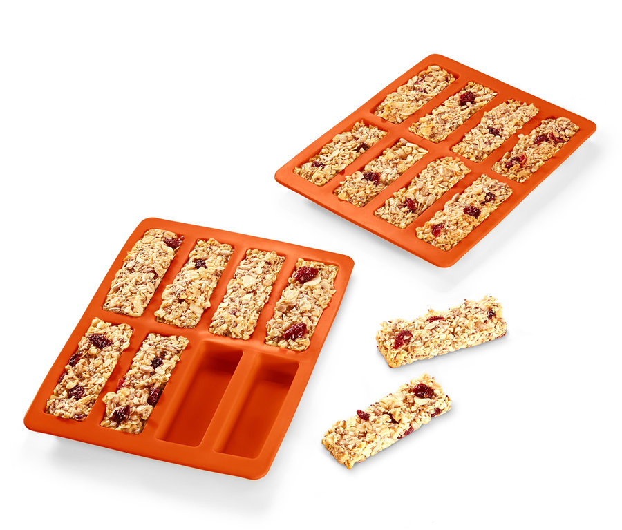 Dwie pomarańczowe foremki do batonów musli, 2 sztuki, jedna pełna batonów i dwa batony obok.