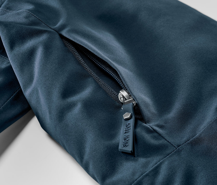 Zbliżenie na granatową kurtkę narciarską z zamkiem błyskawicznym.