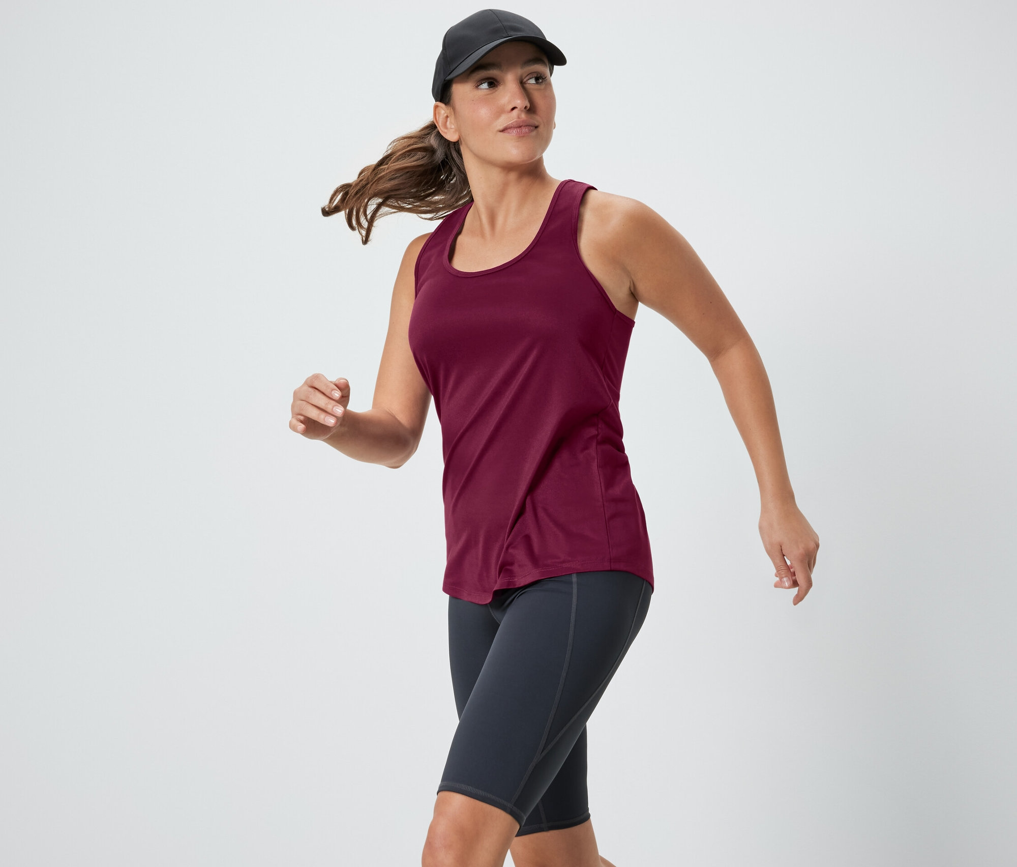 Kobieta biegnie w różowym topie funkcyjnym z dwuczęściowego zestawu.