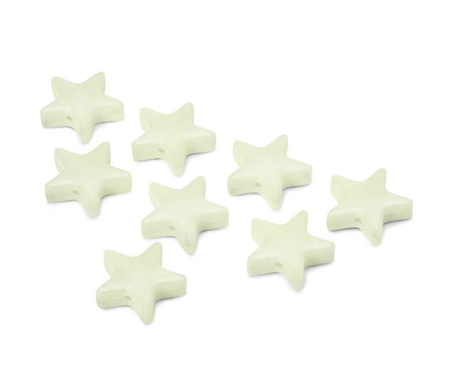 Osiem świecących w nocy klipsów w kształcie gwiazdy leży na białej powierzchni.