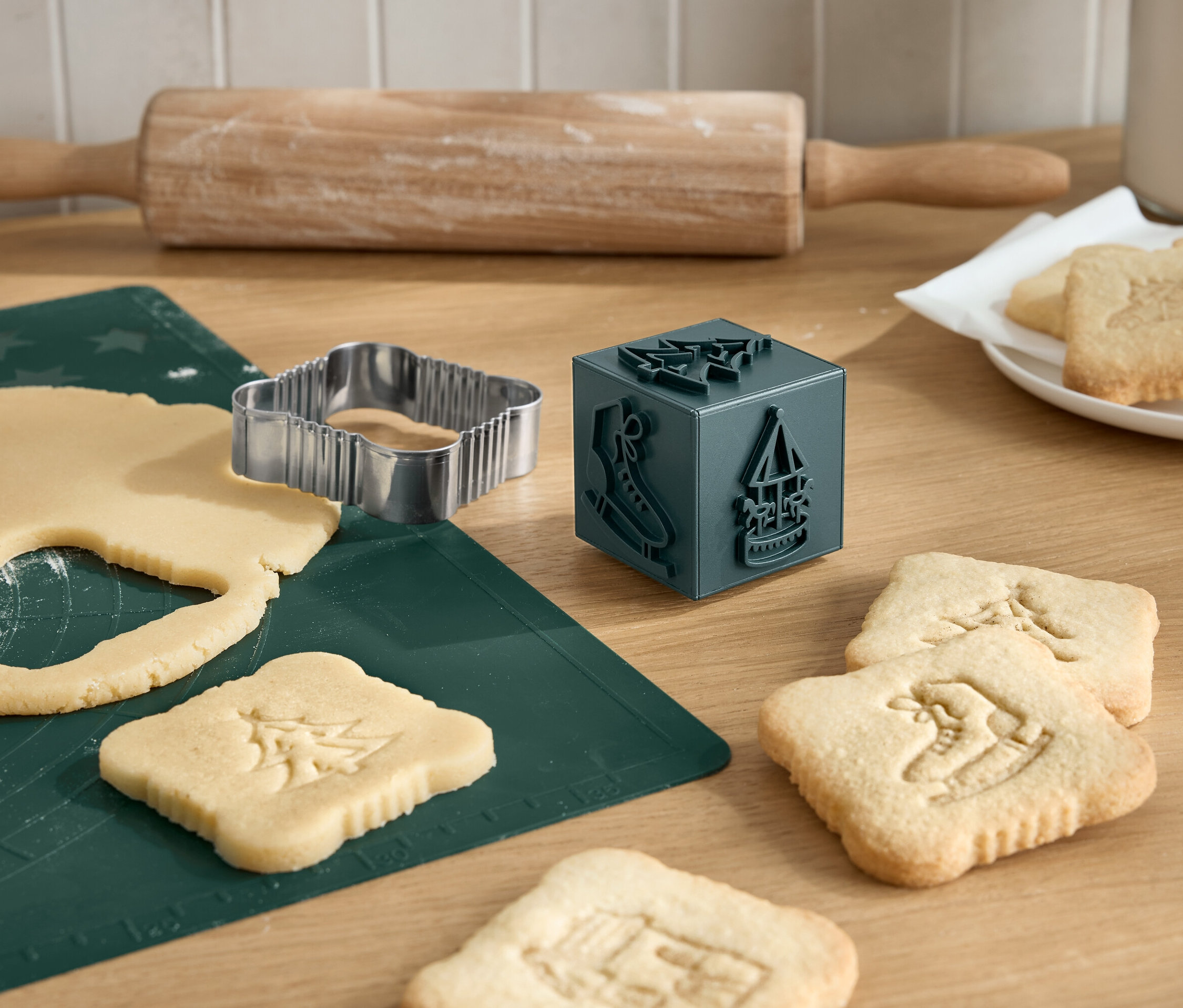 Wykrawanie świątecznych ciasteczek za pomocą foremki, wałka i stempla do ciasteczek.