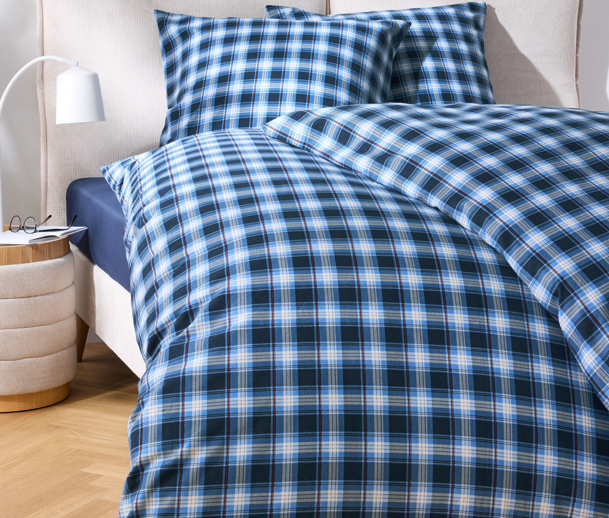 Pościel w niebieską kratę na łóżku.
