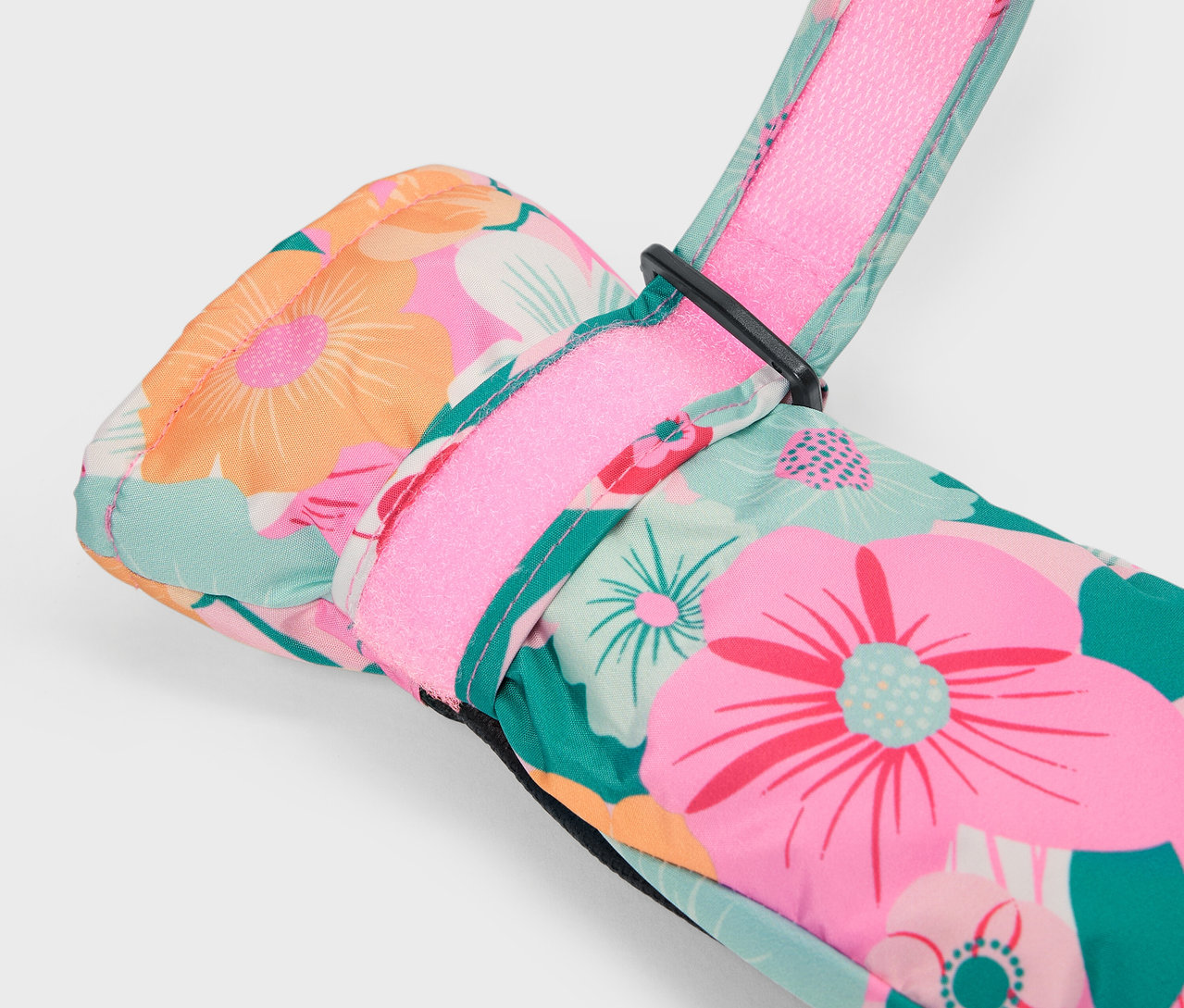 Zbliżenie na kolorową, kwiecistą rękawicę narciarską z różowym paskiem.