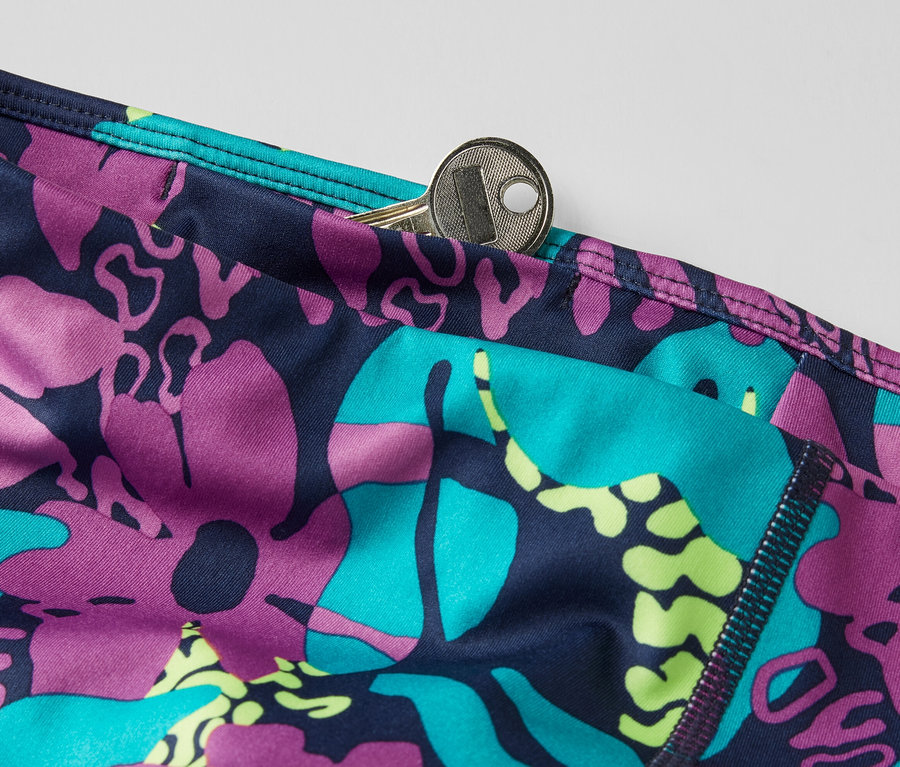 Zbliżenie na krótkie legginsy z nadrukiem na całej powierzchni i kluczem w kieszeni.