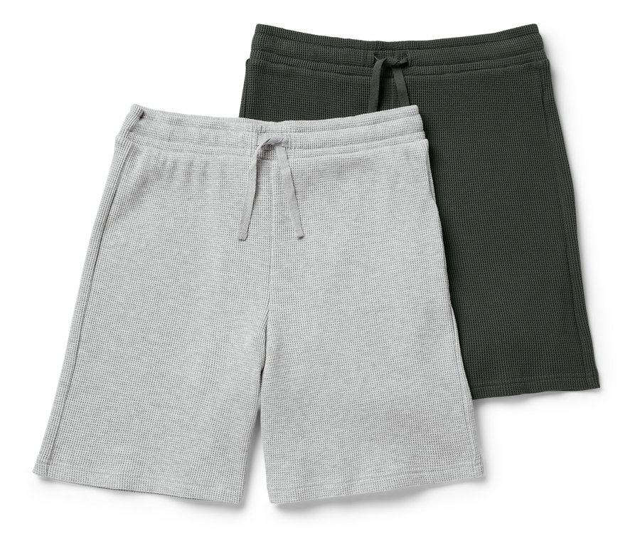 Dwie szorty waflowe, jedne szare, a drugie ciemnozielone, leżą na sobie.