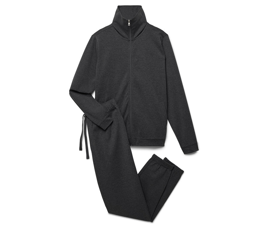 Szary dres ze bluzą na zamek i spodniami leży na białym tle.