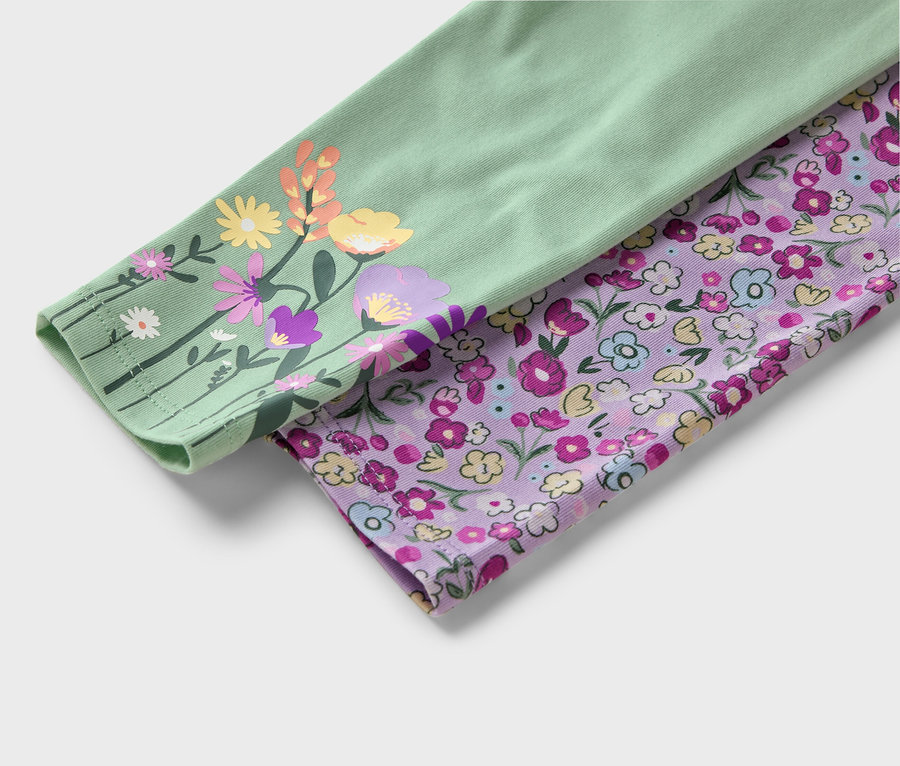 Szczegół dwóch materiałowych rękawów. Jeden jest jasnozielony z kolorowymi kwiatami, drugi fioletowy z małymi kwiatkami.